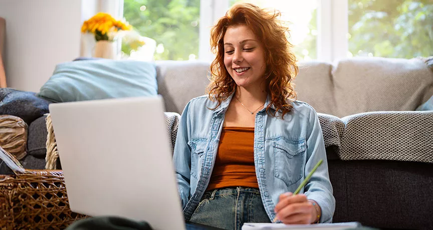 mulher sorrindo em frente ao computador.