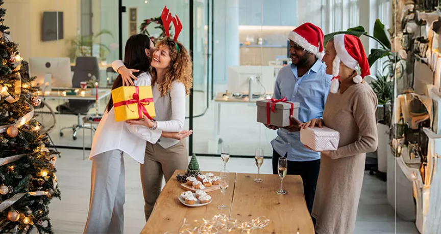 pessoas trocando presentes de natal em escritório.
