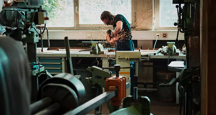 pessoa utilizando serra circular em oficina.