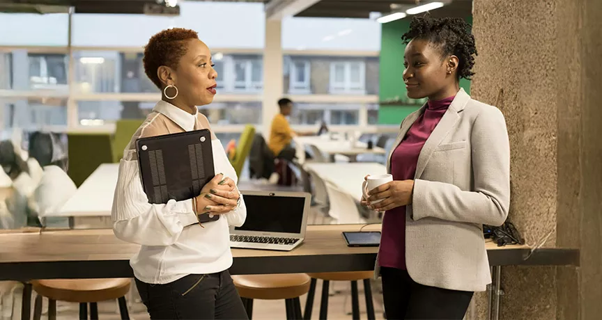 Duas pessoas conversam no escritório