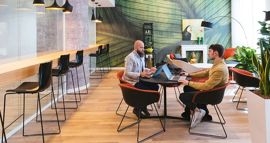 Imagem mostra duas pessoas em reunião no escritório