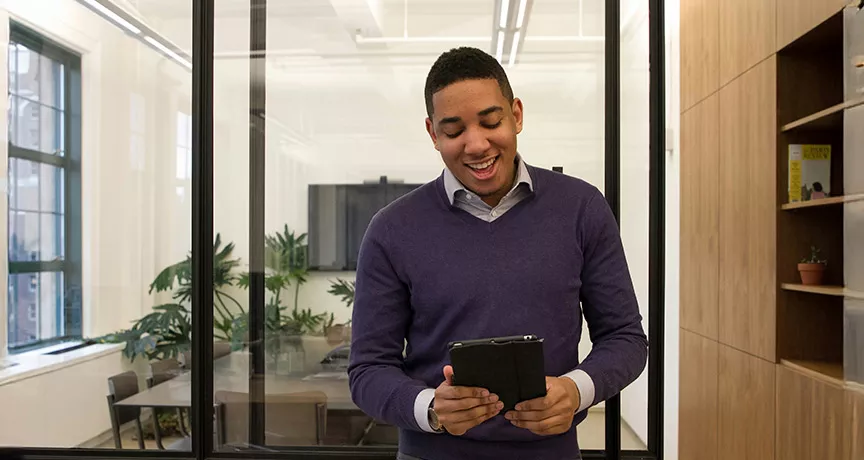 Foto mostra uma pessoa no escritório trabalhando no seu tablet