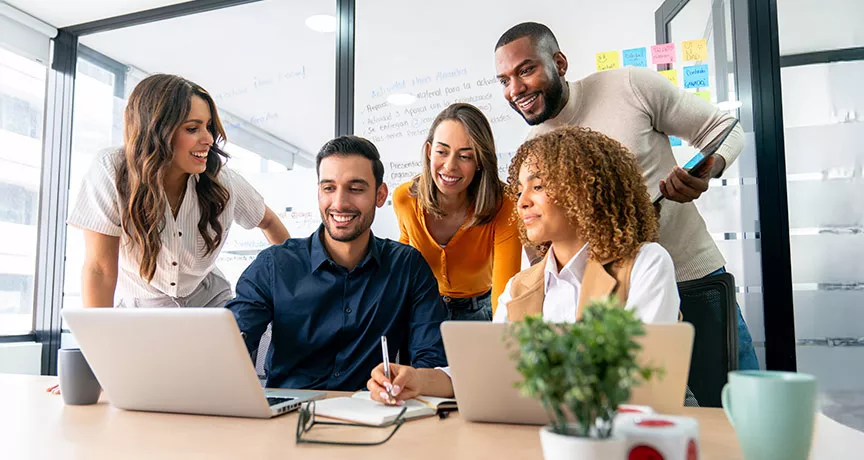 time reunido em torno de notebook.