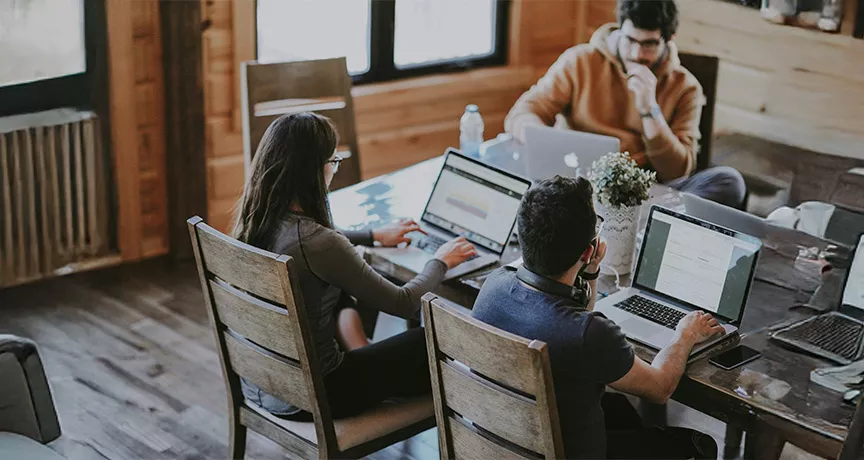 Foto mostra um grupo de pessoas trabalhando em um escritório