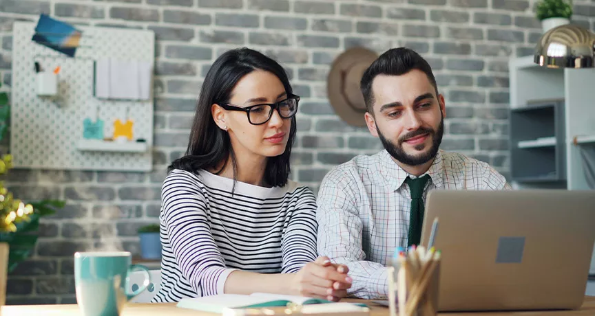 Foto mostra um chefe trabalhando uma pessoa de sua equipe