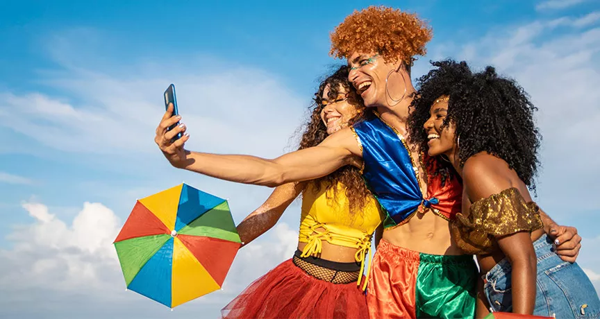 pessoas com roupa de carnaval tirando foto.