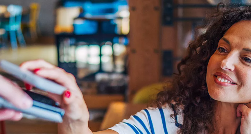 mulher pagando compra com celular.