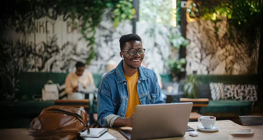 homem sorrindo enquanto usa o notebook.