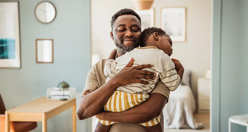 pai segurando o filho no colo.