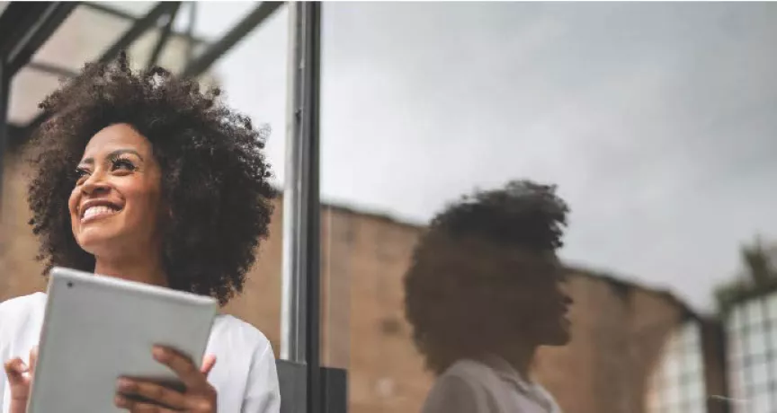 Mulher negra com tablet sorrindo