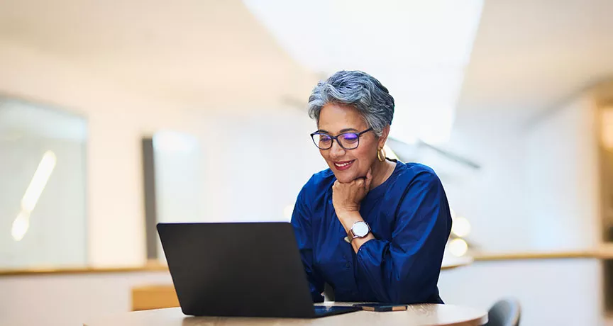 mulher sorrindo para computador.