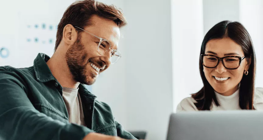 Homem e mulher em um ambiente corporativo, sorrindo 