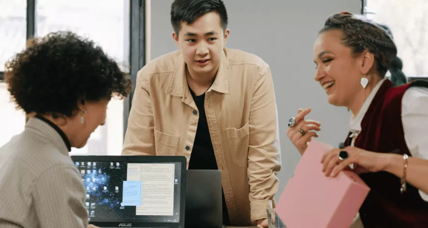homem e duas mulheres conversando em ambiente de trabalho