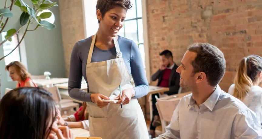 homem em restaurante sendo atendido por uma mulher