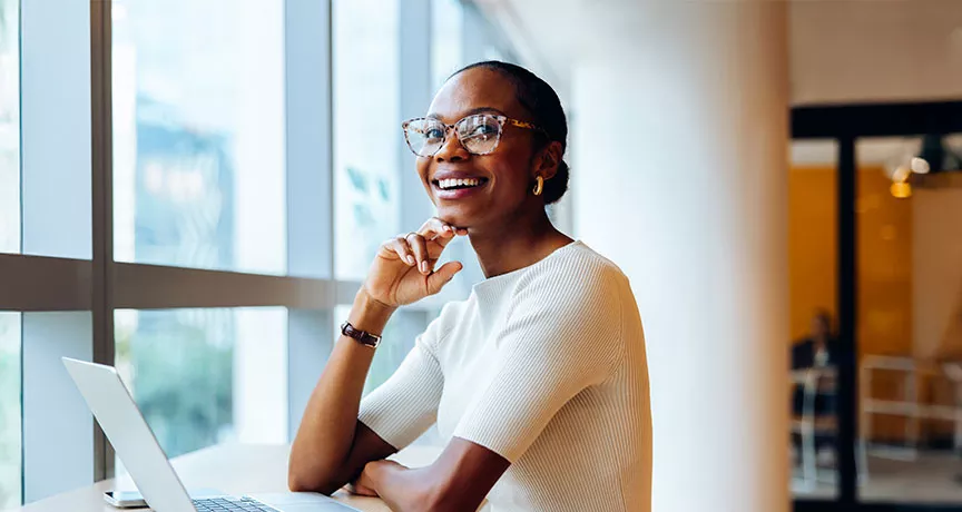 Foto mostra uma mulher animada no seu local de trabalho