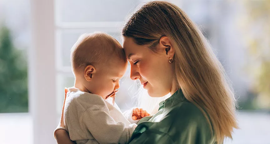 mulher com a testa encostada em seu neném.