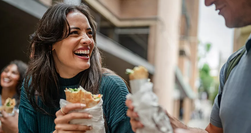 mulher almoçando e sorrindo.