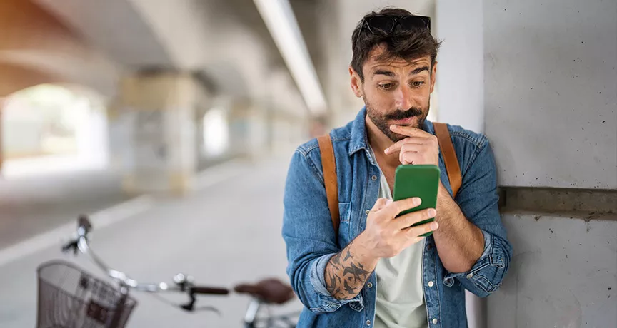 homem olhando o celular depois de andar de bicicleta.