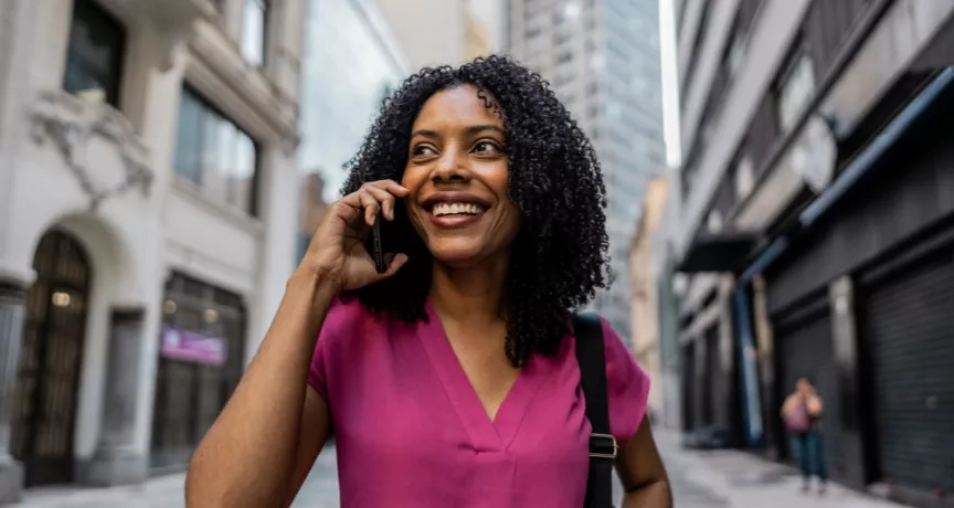 mulher negra, segurando o celular e sorrindo