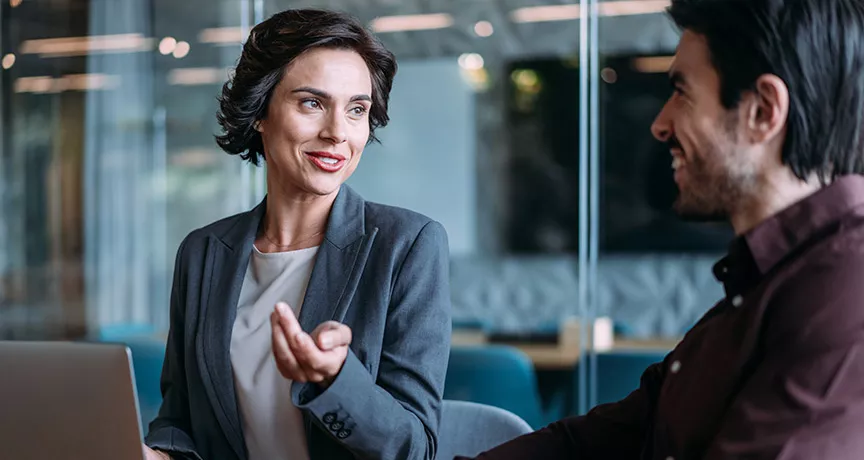 duas pessoas conversando no trabalho.