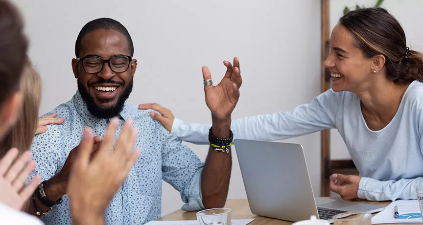 pessoas sorrindo juntas no trabalho.