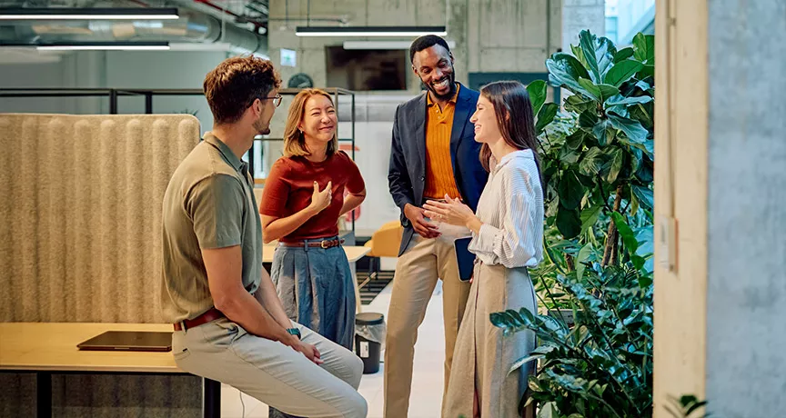 conjunto de pessoas conversando em ambiente corporativo.