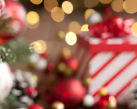 Imagem mostra uma mesa de Natal com um presente ao fundo