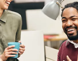 pessoas sorrindo e conversando em ambiente corporativo.