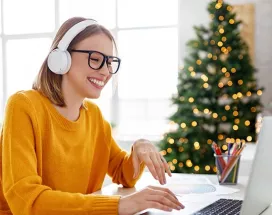 Colaboradora trabalha em home office com árvore de Natal ao fundo