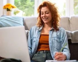 mulher sorrindo em frente ao computador.