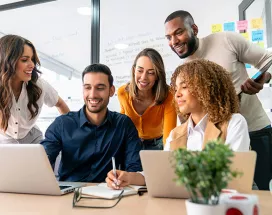 time reunido em torno de notebook.