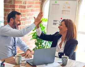 duas pessoas fazendo "toca aqui" no trabalho.