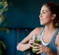 Imagem mostra uma mulher branca tomando um suco verde