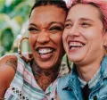 Imagem mostra duas mulheres abraçadas sorrindo e comendo felizes