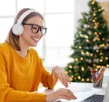 Colaboradora trabalha em home office com árvore de Natal ao fundo