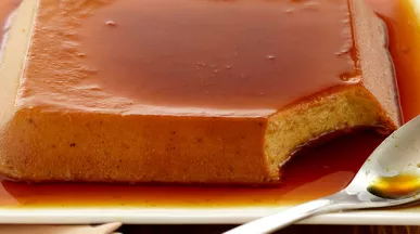 uma travessa braca com servindo um pudim de banana com cobertura caramelizada 