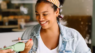 Mulher paga conta em café usando seu cartão Pluxee no Apple Pay