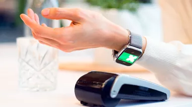 Tecnologias do futuro do varejo sendo ilustradas por uma mulher pagando sua conta usando seu smartwatch