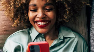 Mulher deitada no sofá confere as ofertas do app Pluxee Brasil