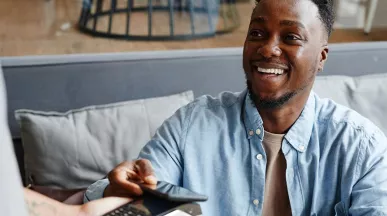 Homem paga conta com vale-refeição Pluxee no seu restaurante favorito