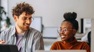 Dupla de colegas de trabalho trabalha tranquila no ambiente saudável de uma empresa humanizada