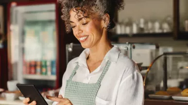 Empreendedora confere o fluxo de vendas em seu estabelecimento. Veja no infográfico como começar a empreender.