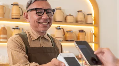 Dono de estabelecimento aceita pagamento com Pluxee Gift pelo smartphone do cliente