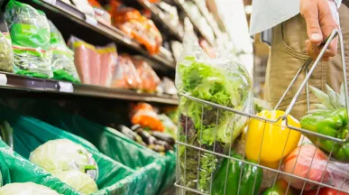 Pessoa escolhe verduras e legumes frescos em um supermercado
