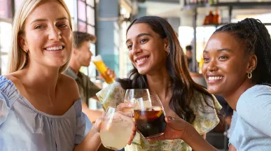 Foto mostra 3 amigas tirando uma foto juntas no restaurante