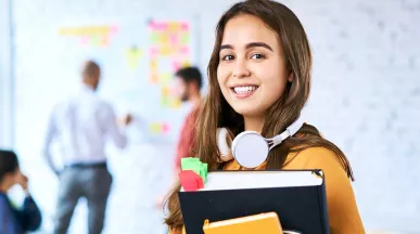 Jovem profissional está no escritório levando material para sua reunião