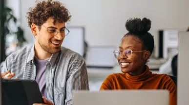 Dois colegas de trabalho veem juntos o andamento de um projeto