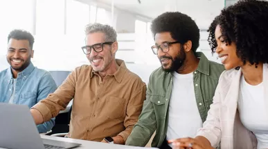 Equipe de quatro pessoa trabalha junta em um escritório