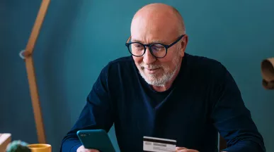 Foto de um homem usando o celular em sua casa