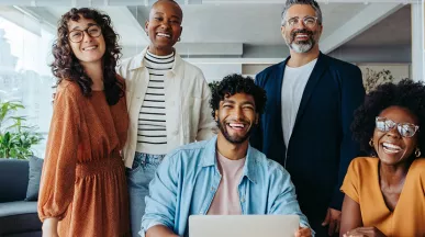 Imagem mostra uma equipe de trabalho motivada e feliz no escritório
